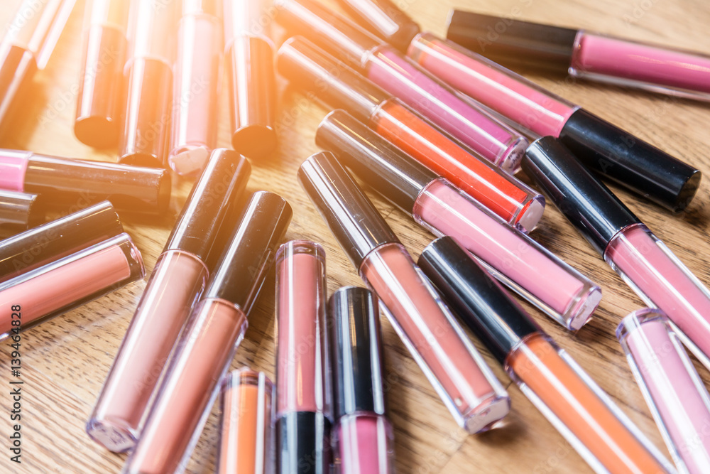 heap of bottle liquip lipstick on wooden table with free copyspace