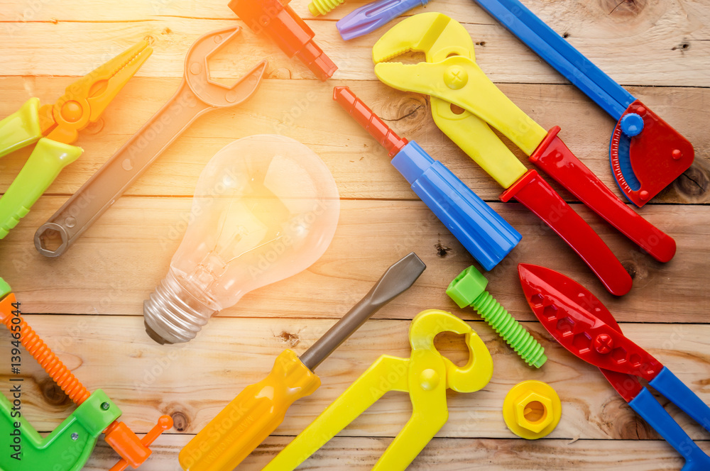 tools and glow lightbulb with instruments toys on wood texture.jpg