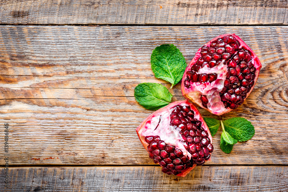 sliced pomegranate on wooden background top view