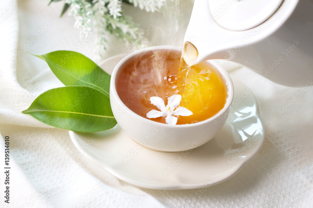 Close up pouring hot jasmine tea in a white tea cup ,  Tea ceremony time concept