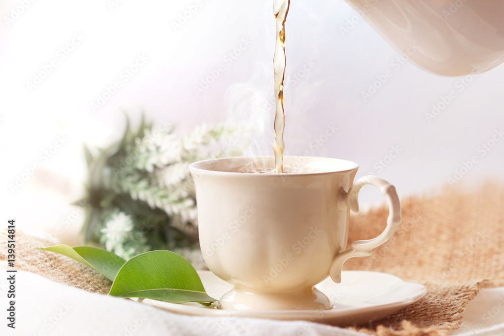 Close up pouring hot jasmine tea in a white tea cup ,  Tea ceremony time concept