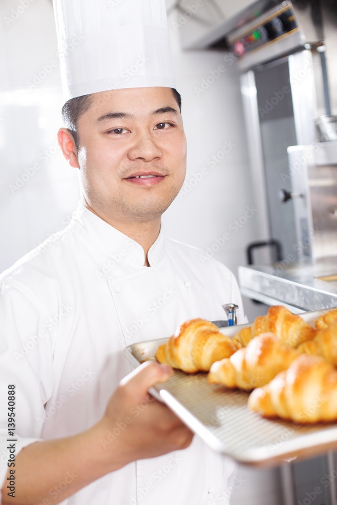 young man chelf makes bread in kitchen