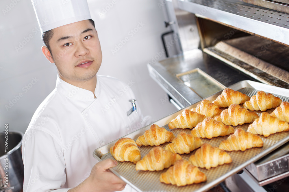 young man chelf makes bread in kitchen