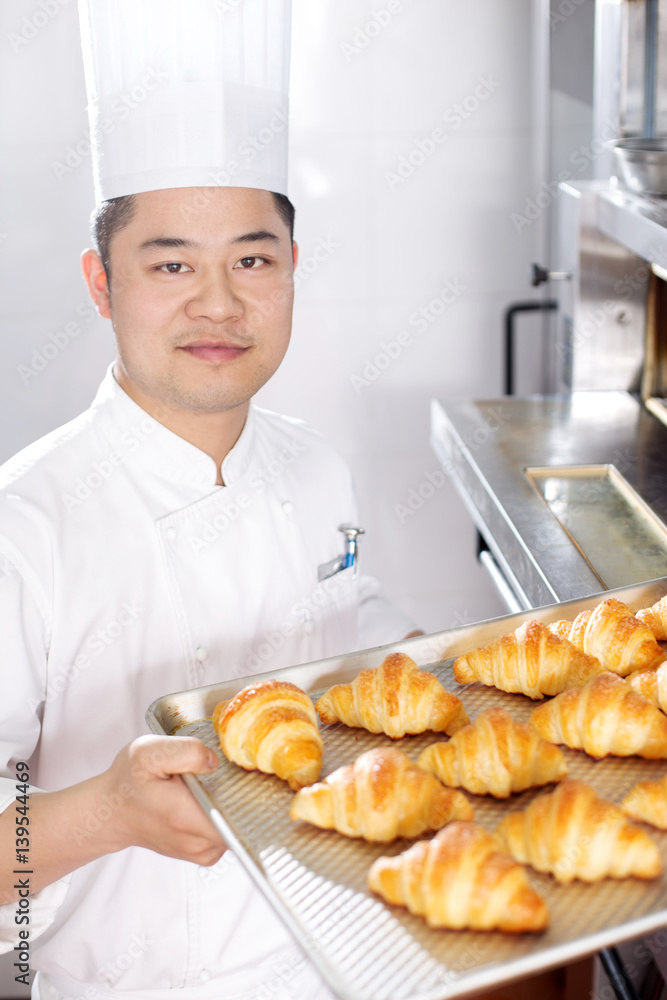 young man chelf makes bread in kitchen