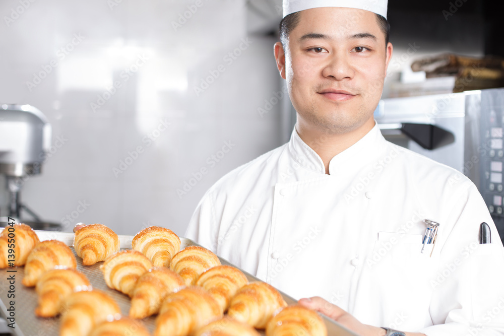 young man chelf makes bread in kitchen