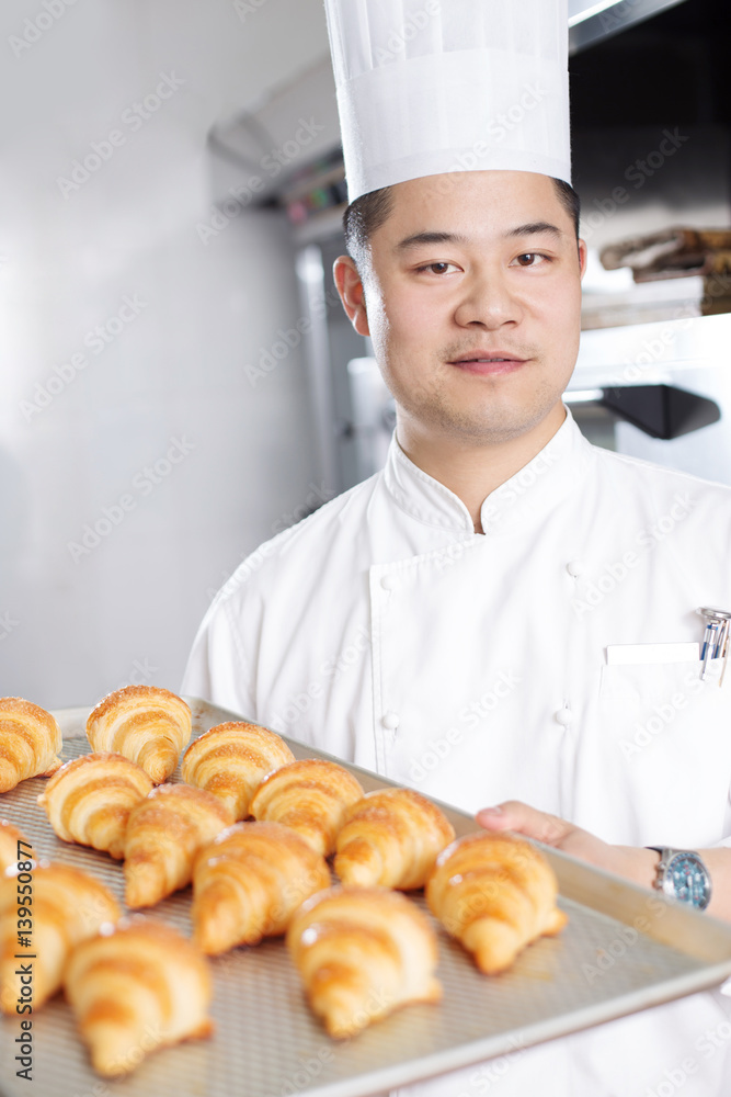 young man chelf makes bread in kitchen