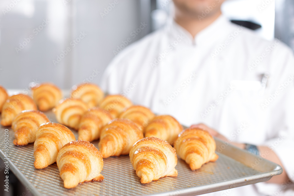 young man chelf makes bread in kitchen