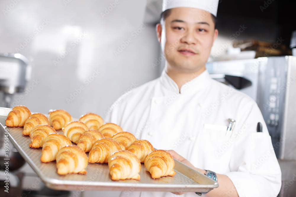 young man chelf makes bread in kitchen