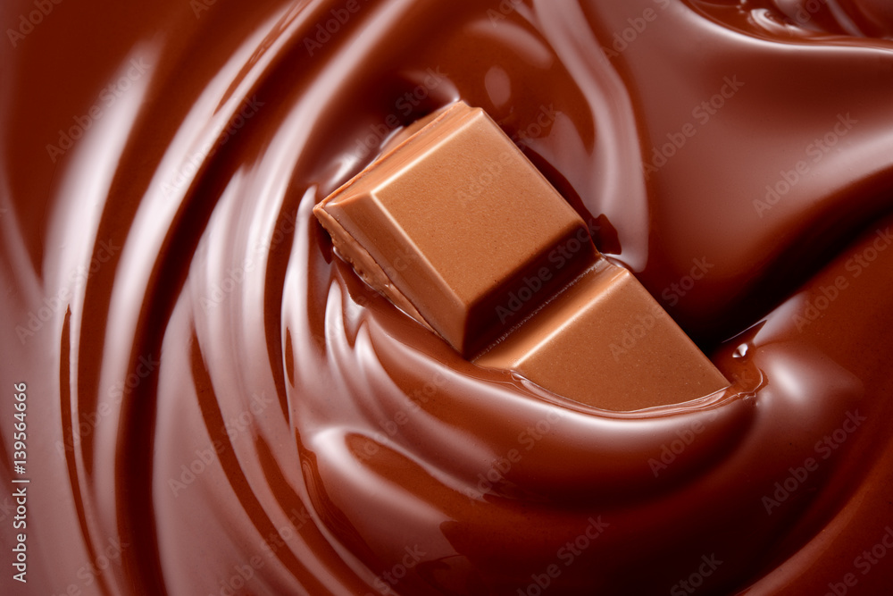 Melted hot liquid chocolate with chocolate pieces. Background.