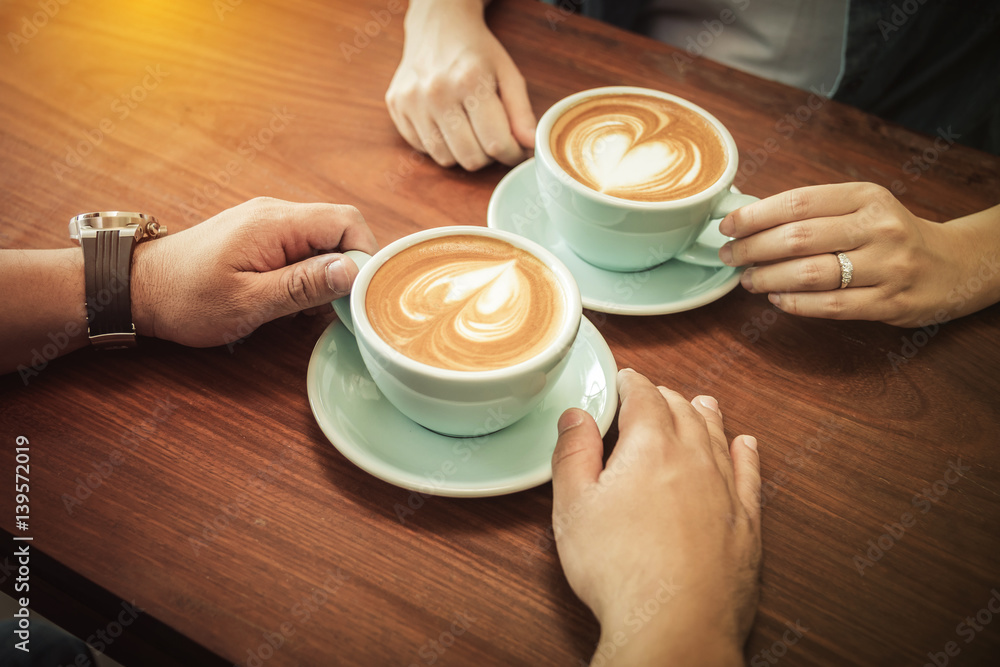 A couple drinking coffee at cafe together