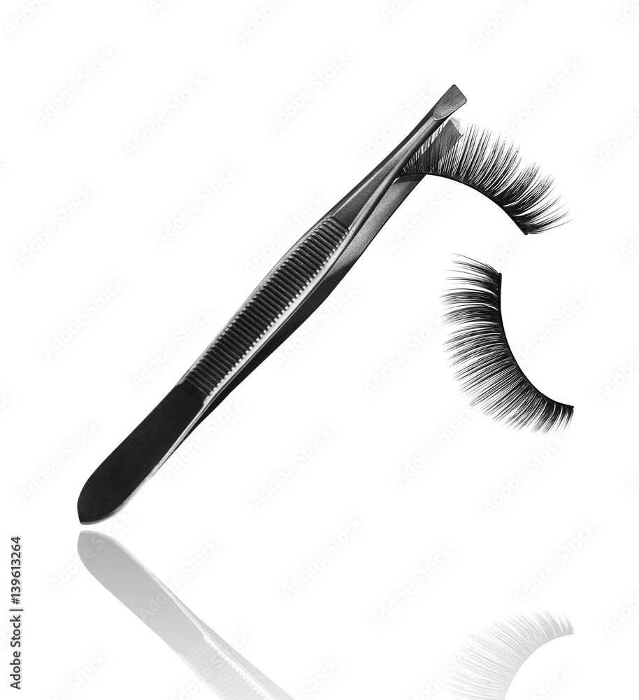 pincers with falling false eyelashes isolated on white background