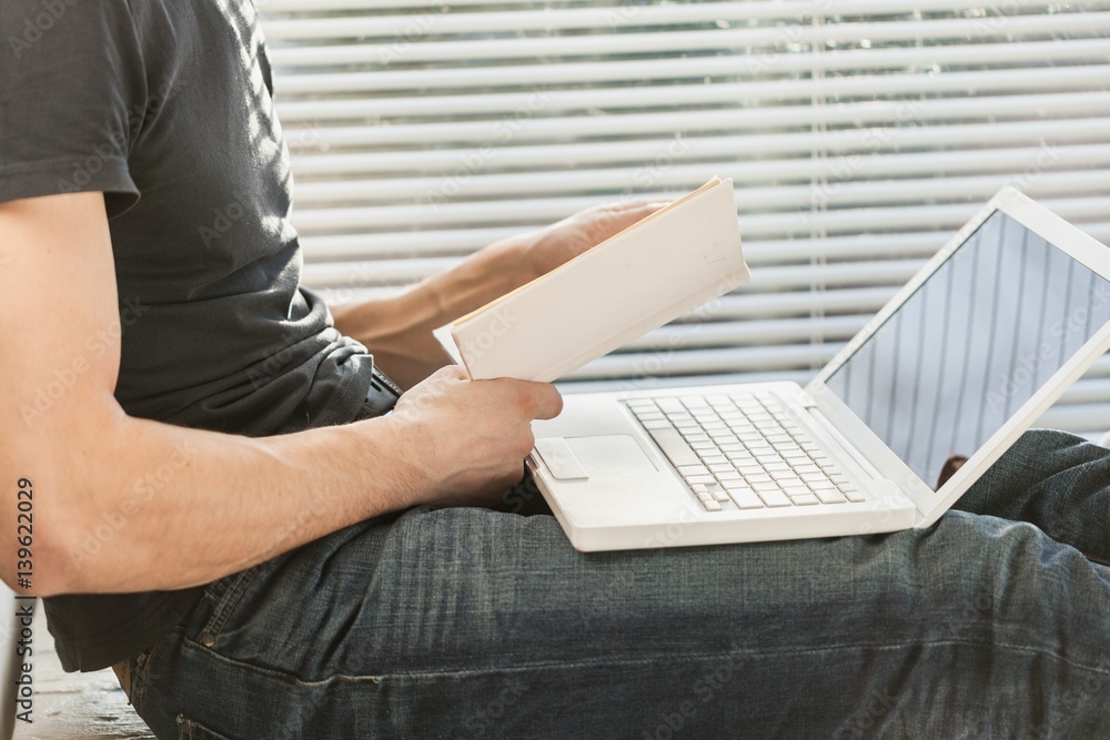 Business man works on digital tablet and laptop.