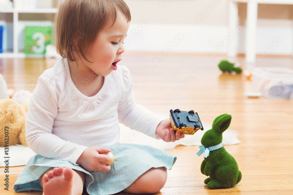 Happy toddler girl playing with toys