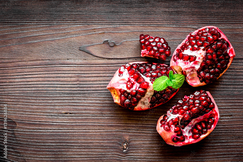 sliced pomegranate on wooden background top view