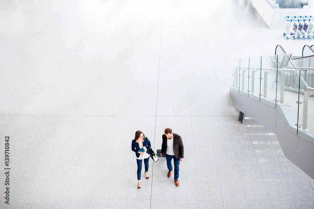 Business couple walking with baggage at the airport. Top, wide angle view with copy space