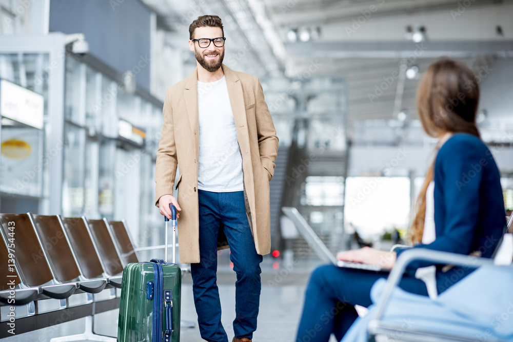 Elegant businessman in the coat meeting businesswoman at the waiting hall of the airport