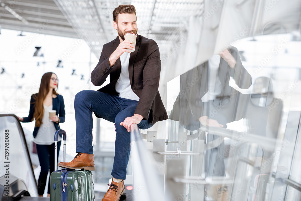 Business couple with coffee to go at the airport. Business travel concept