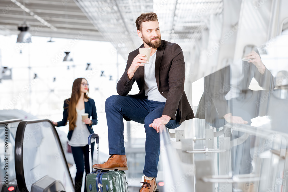 Business couple with coffee to go at the airport. Business travel concept