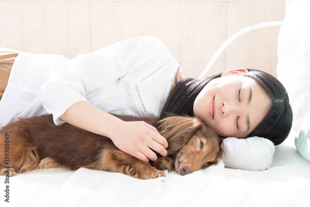 young asian woman sleeping with dog