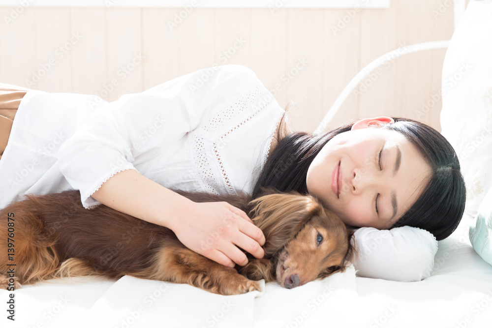 young asian woman sleeping with dog