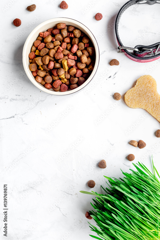 dry dog food in bowl on stone background top view