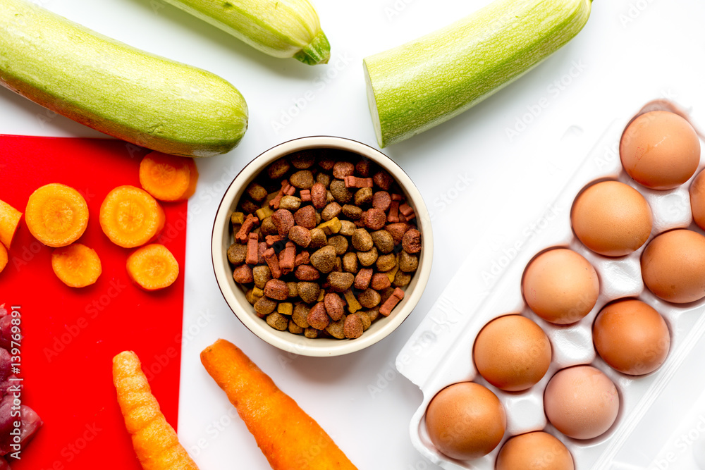 Dogfood set with vegetables, eggs and meat on table background top view