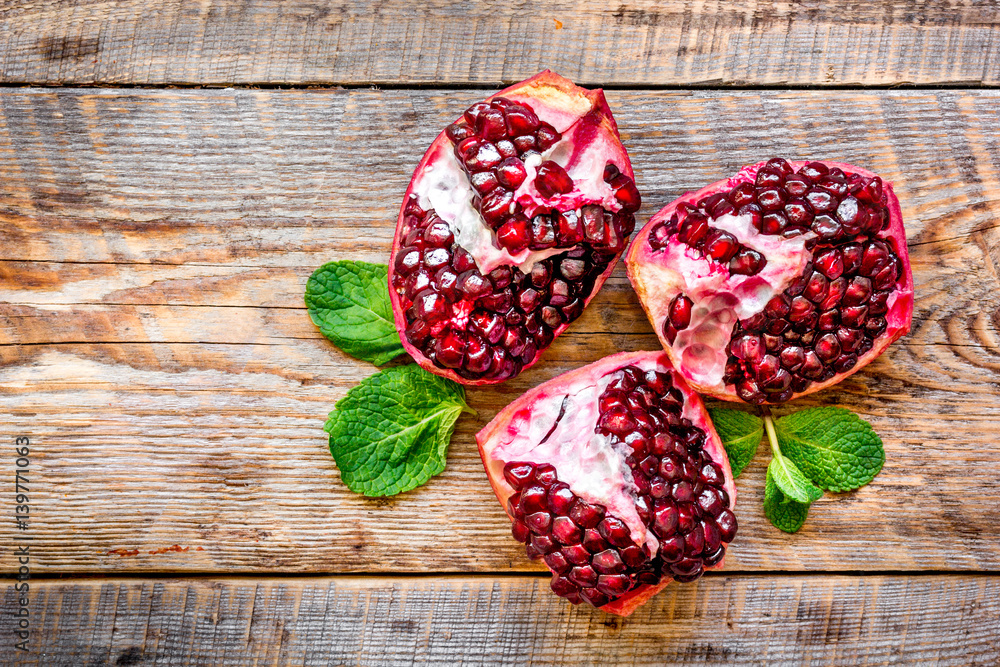 sliced pomegranate on wooden background top view