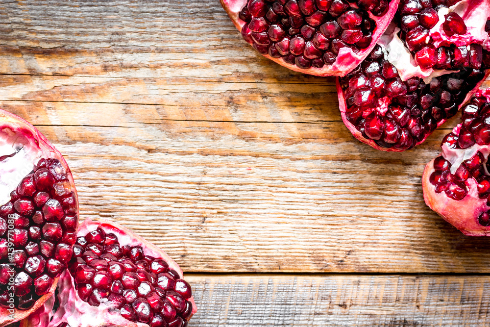 sliced pomegranate on wooden background top view