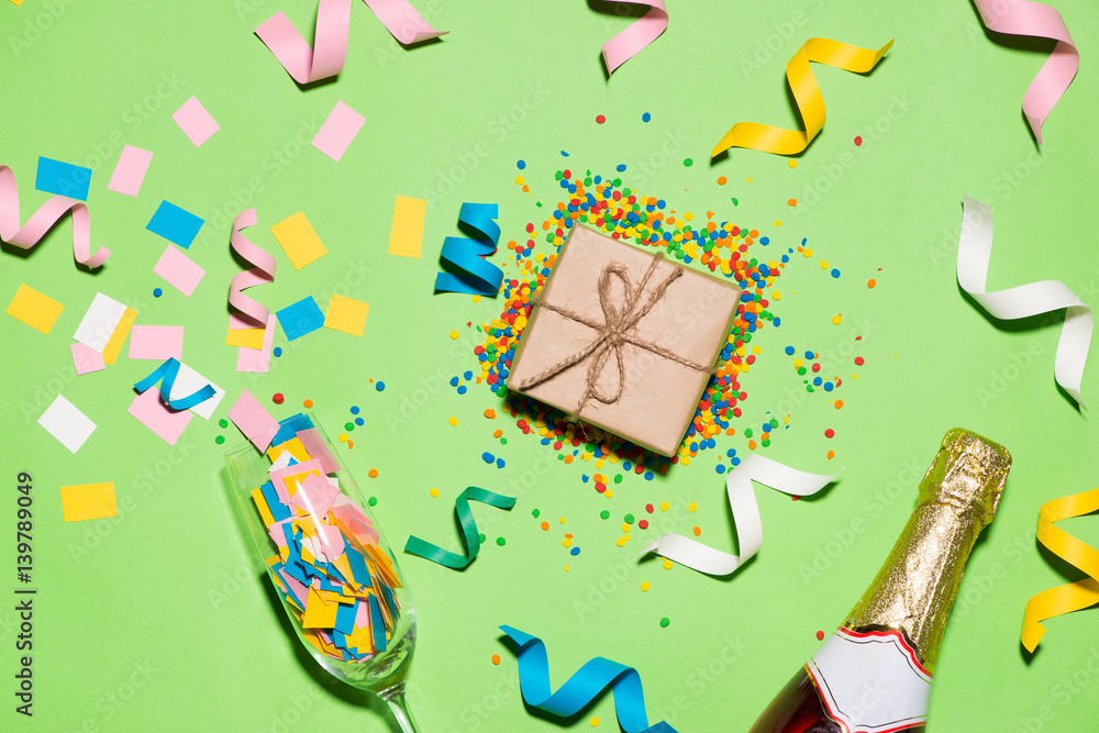 Celebration Flat lay. Gift box with colorful party items on green background.