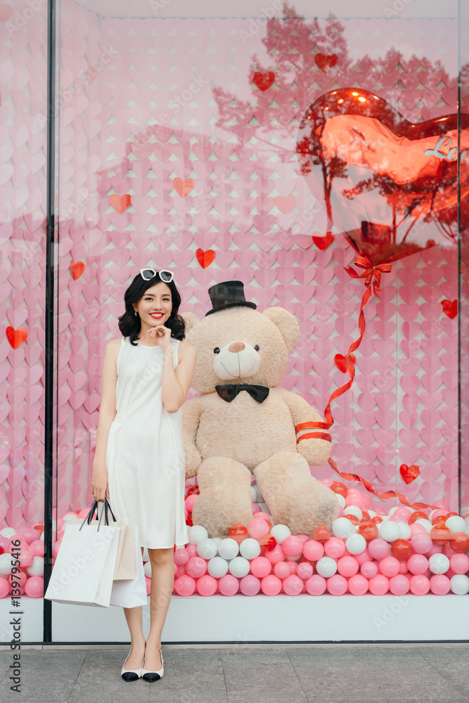 Beautiful asian girl with shopping bags standing outside the mall