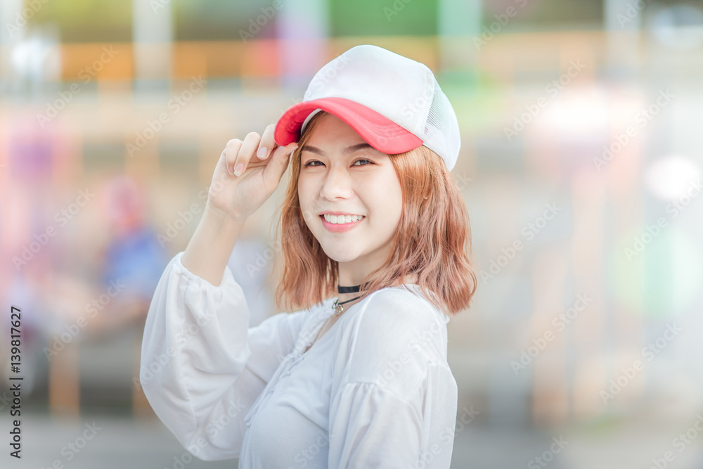 Outdoor portrait of a young beautiful fashionable happy smilng lady posing on  Model wearing hat cap