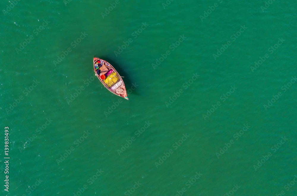 Fishing boat floating in the sea. The beautiful bright blue water in a clear day.Aerial view.Top vie