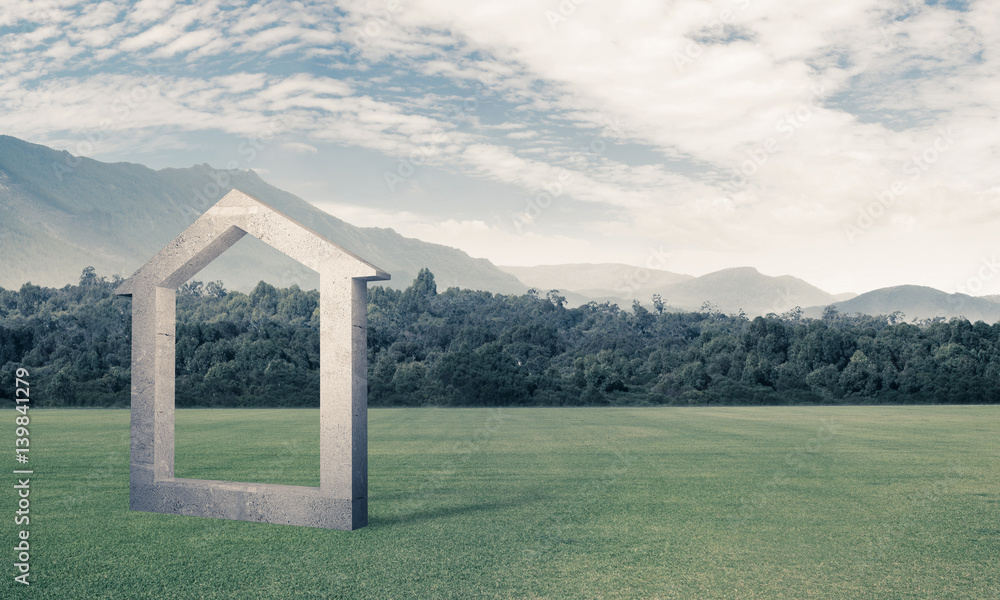 Conceptual background image of concrete home sign on green grass