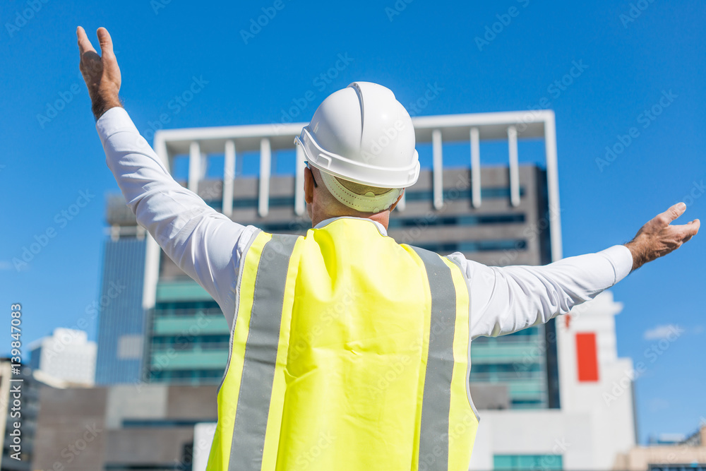 Senior foreman in glasses doing his job at building area on sunny day