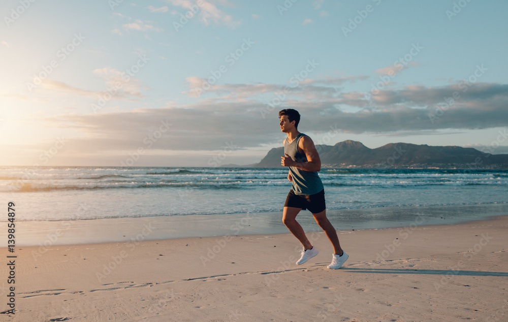 Fit young man jogging on the beach