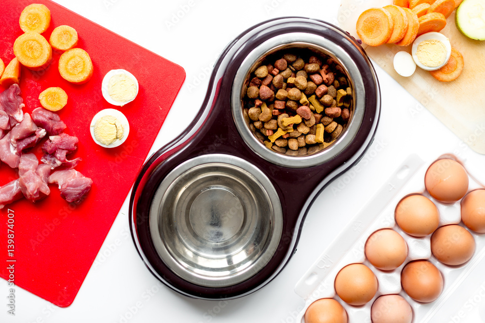 Dogfood, eggs, meat, carrot and courgette on table background top view