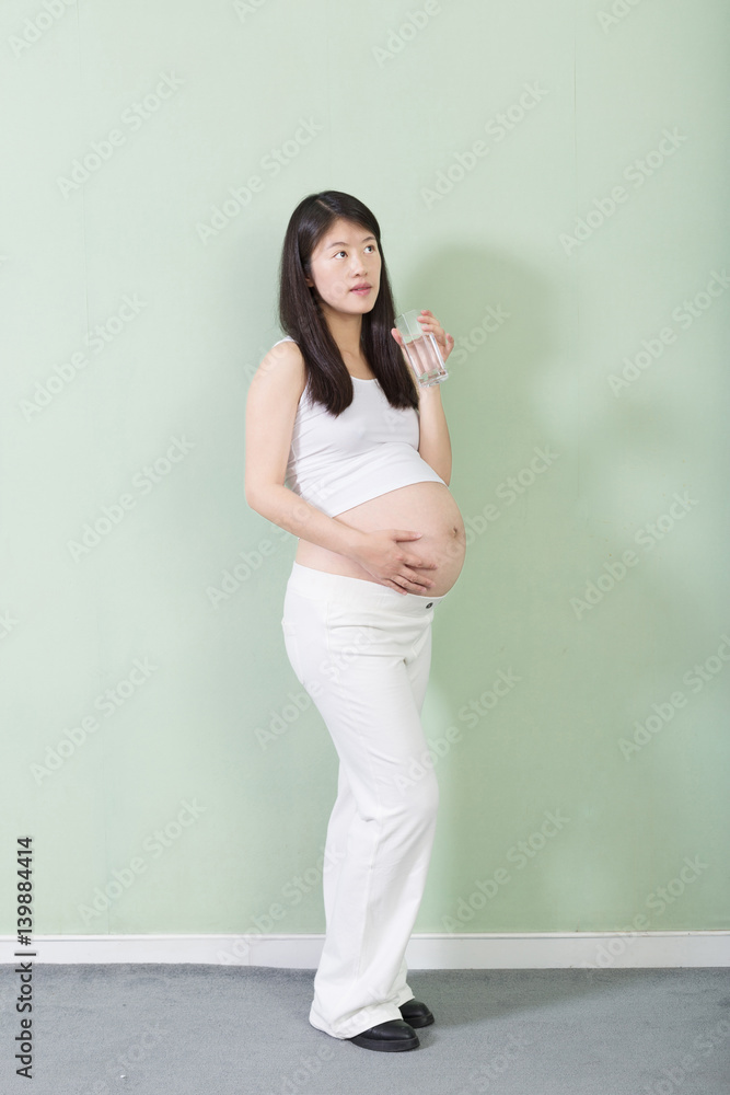 young pretty pregnant woman on background