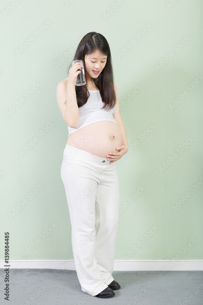 young pretty pregnant woman on background