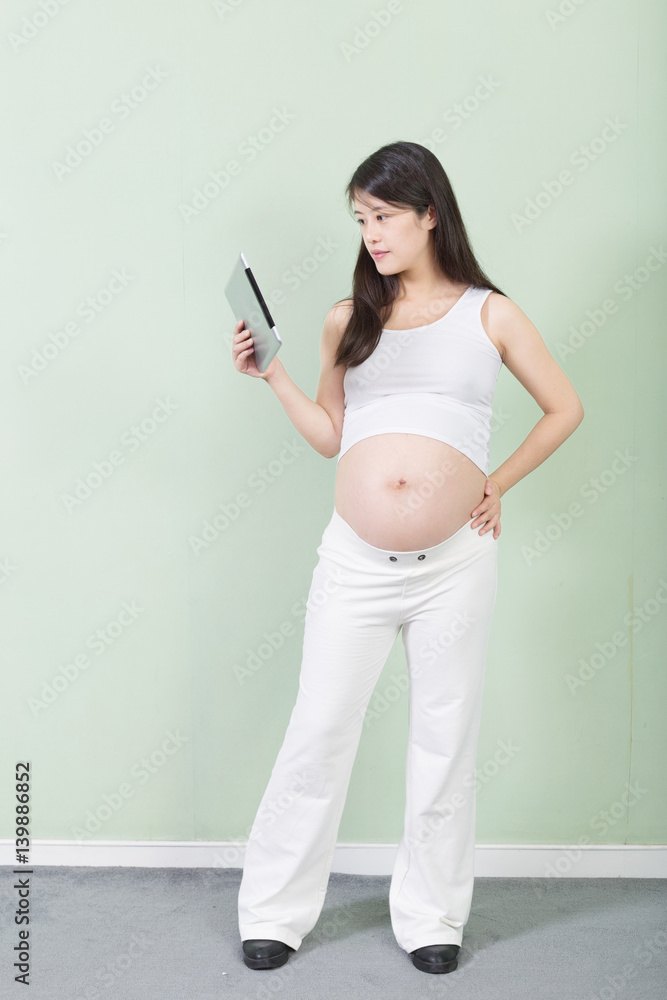 young pretty pregnant woman with tablet