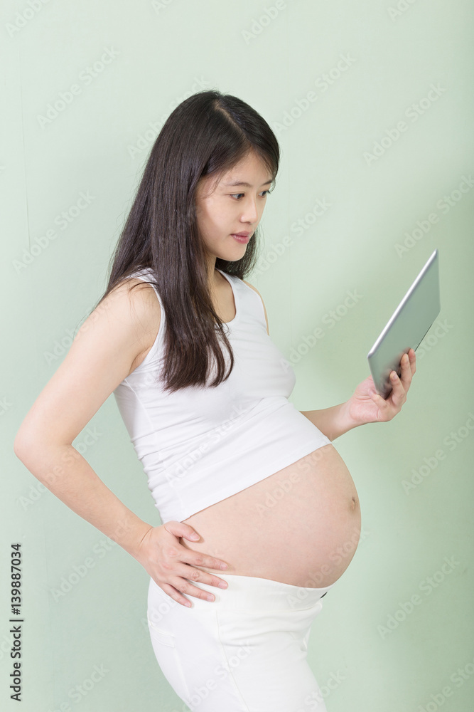 young pretty pregnant woman with tablet