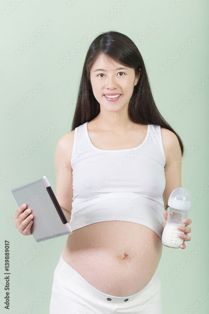 young pretty pregnant woman with bottle