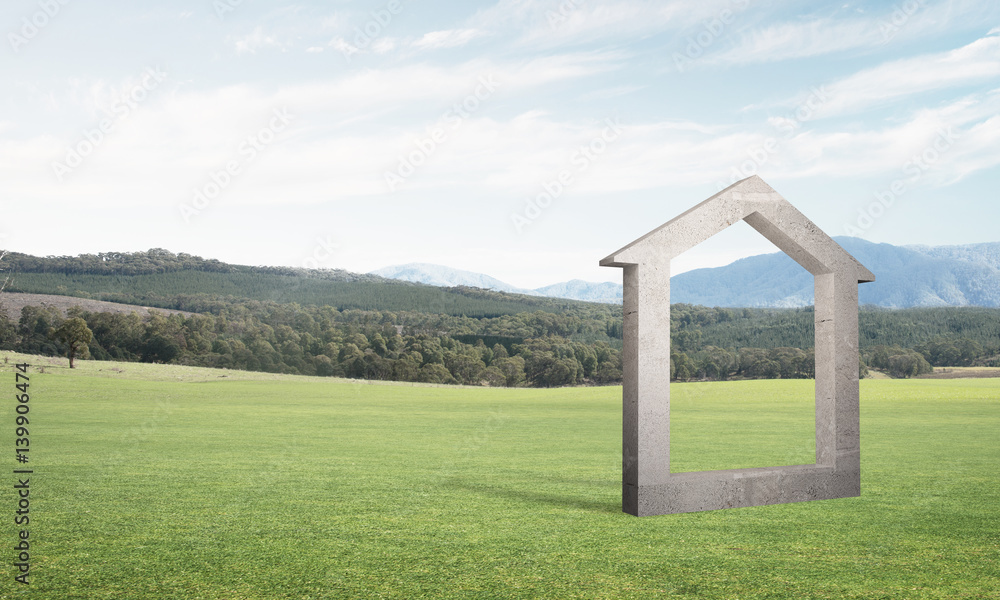 Conceptual background image of concrete home sign on green grass