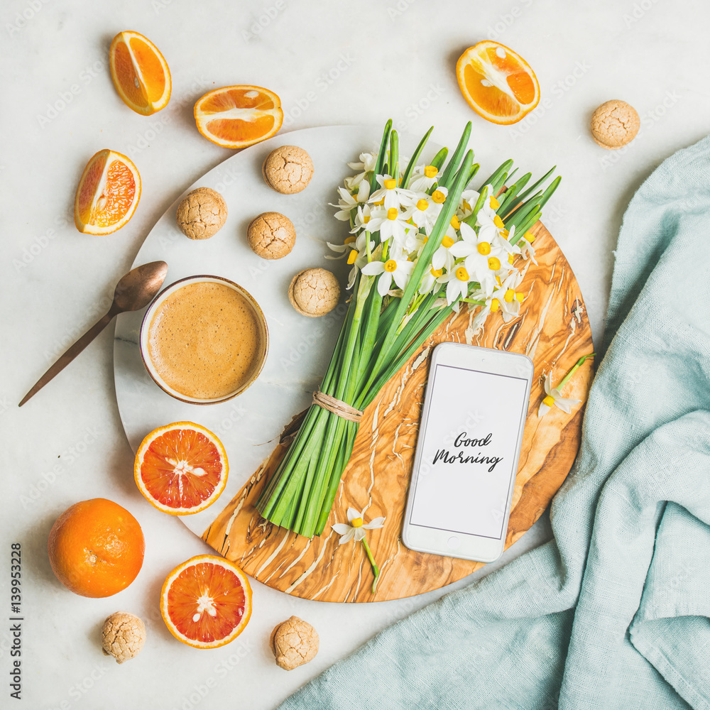 Cup of morning coffee, cookies, red oranges, bucket of spring flowers and mobile phone with text Goo