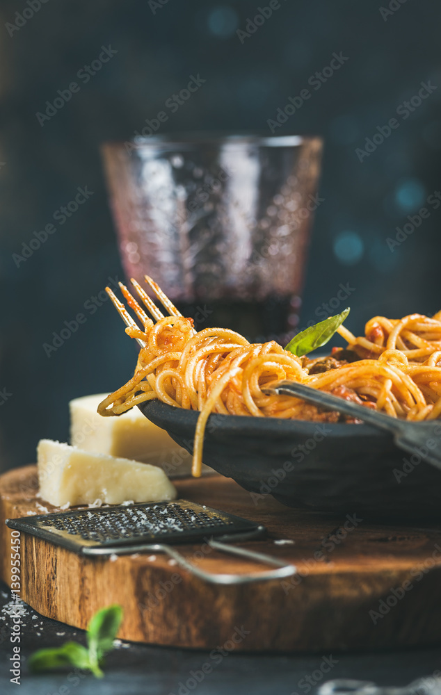 Italian pasta dinner. Spaghetti with meatballas, fresh basil, parmesan cheese and red wine in glass 