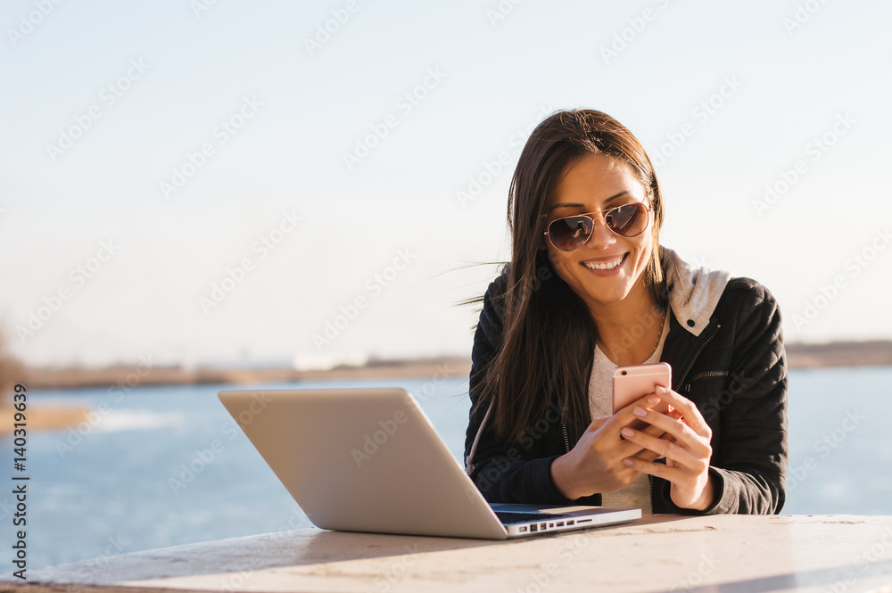 女孩在户外工作时用手机阅读男友的短信