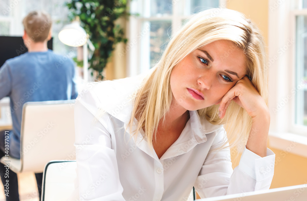 Bored young woman sitting at her desk