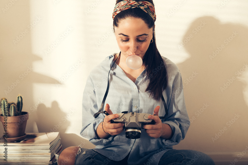 Casual young woman photographer blowing bubbles