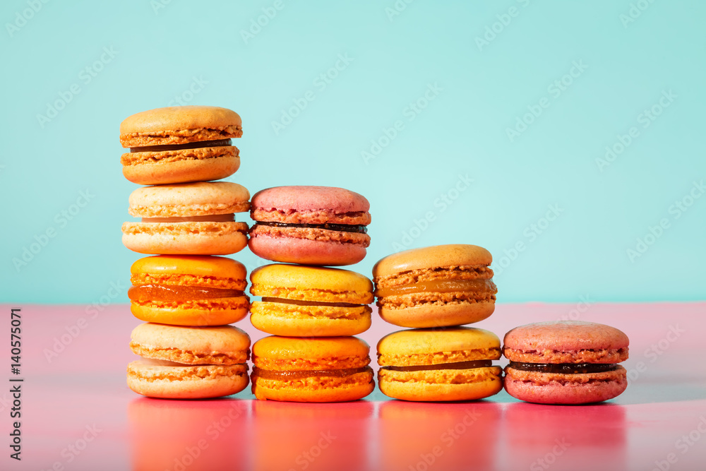 Colorful macarons on bright pastel background