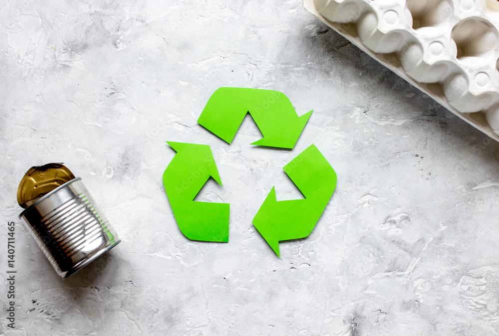 waste recycling symbol with garbage on stone background top view mockup