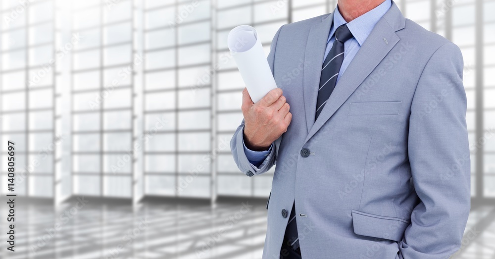 Architect Torso holding plans in a corridor against windows